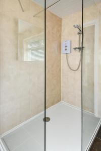 une douche avec une porte vitrée dans une salle de bain dans l'établissement 4 Glyn y Marian, à Llanbedrog