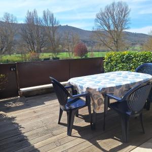 a table and chairs on a deck with a view of a field at Mazet l'olivier 2 in Saint-Martin-de-Brômes +5 photos