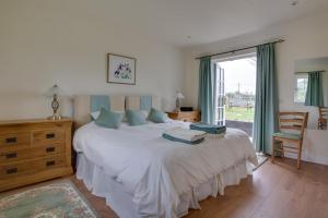 ein Schlafzimmer mit einem großen weißen Bett und einem Fenster in der Unterkunft Pound Hill Cottage in Frittenden