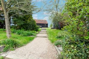 einen Weg, der zu einem Haus in einem Garten führt in der Unterkunft Pound Hill Cottage in Frittenden