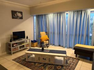 a living room with a couch and a tv at Palmsbeach 5 in Strand