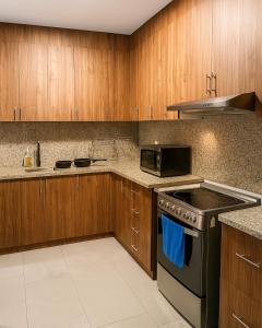 a kitchen with wooden cabinets and a stove top oven at Luxury Terrace Suite in Cuenca in Cuenca