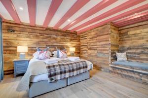 a bedroom with a bed and a wooden wall at The Barn in Croyde