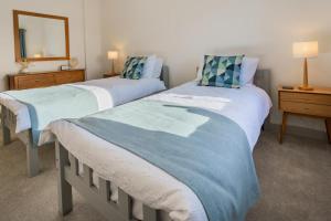 una camera da letto con due letti e uno specchio di Ty Nant a Dinas