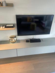 a flat screen tv sitting on top of a table at 60a Willesden Lane in London