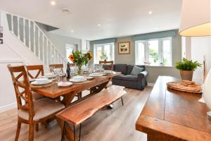 a dining room with a table and a couch at Egryn Bach in Abersoch