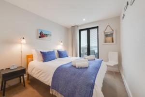 Un dormitorio con una cama grande con almohadas azules. en 10 Ocean Point, en Croyde