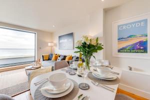 Un comedor con una mesa y un sofá. en 10 Ocean Point, en Croyde
