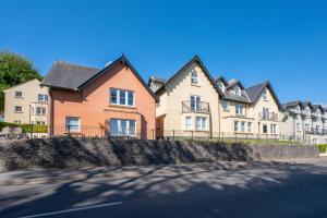 una fila de casas con una valla delante de una calle en Bay View, en Saundersfoot