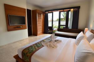 una habitación de hotel con una cama y un televisor en Ubud Wana Villa, en Ubud
