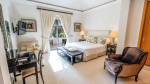 une chambre avec un lit, un bureau et une chaise dans l'établissement Villa Dasha by the Lake, à Quinta do Lago 53 autres photos