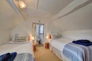 deux lits jumeaux dans une chambre avec fenêtre dans l'établissement Monks Cottage, à Braunton