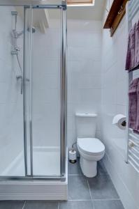 a bathroom with a toilet and a glass shower at The Den in Lynmouth +13 photos