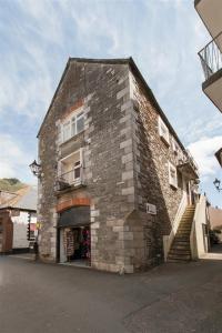 a large brick building with a staircase in front of it at 4 Apartment Pixies Holt in Looe