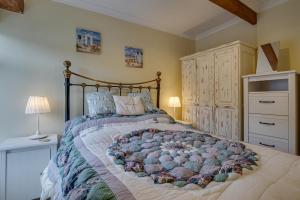 a bedroom with a large bed and a dresser at 4 Apartment Pixies Holt in Looe