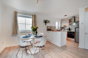 ウーラクームにあるBeach Escapeのテーブルと椅子のあるキッチンとダイニングルーム +9枚の写真