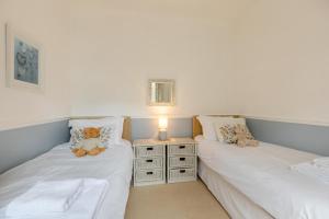 two beds in a room with teddy bears on them at 1 Dolphin Court in Woolacombe