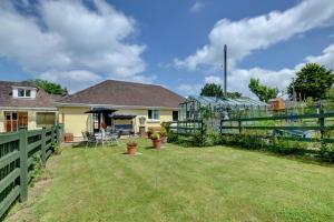 einen Hof mit einem Zaun und einem Haus in der Unterkunft Spindrift Cottage Berrynarbor in Berrynarbor
