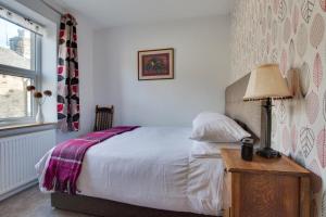 a bedroom with a bed and a lamp on a night stand at Lorna Loom in Skipton