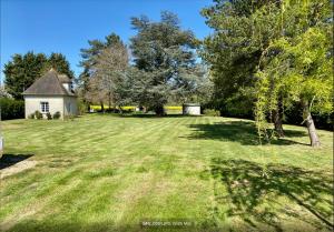 a large grassy yard with a house in the background at Presbytère du 19e siècle in La Chapelle-du-Bois-des-Faulx