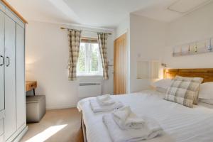 帕兹托Samphire的卧室里有一张白色的床，床上放着毛巾