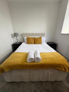 a bedroom with a large bed with two towels on it at 1 Bed Flat - Sleeps 2 - Pets - Parking - Wifi in Kettering