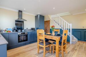 a kitchen with blue cabinets and a table and chairs at Y Golwg in Llanover
