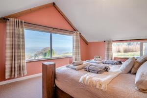 a bedroom with a bed with a large window at Y Golwg in Llanover