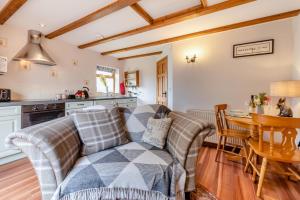 un salon avec un canapé et une table dans l'établissement Otter Cottage at West Ashridge, à Bideford