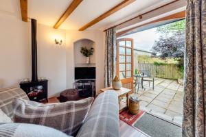 un salon avec vue sur un patio dans l'établissement Otter Cottage at West Ashridge, à Bideford