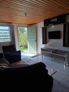 a living room with a couch and a television at Casa Névoa in Canela