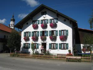 a white building with flower boxes on the windows at Ferienwohnung Heublume, Ferienhof Lochbihler, WertachAllgäu in Wertach
