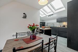 Una cocina con una mesa con un jarrón de flores encima. en Rooftop Rendezvous - St Ives, en St Ives