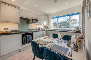Una cocina con una mesa y sillas en una cocina. en Saltwhistle View, en Teignmouth