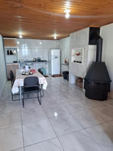 a large kitchen with a table and a stove at Casa Névoa in Canela
