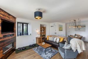 a living room with a couch and a fireplace at Austen Cottage - Swanmoor Grange in Chapelton