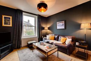 een woonkamer met een bank en een tafel bij Jackdaw Cottage in Embsay