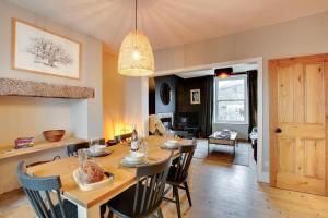 een eetkamer en woonkamer met een tafel en stoelen bij Jackdaw Cottage in Embsay +15 foto's