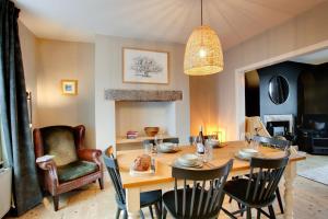 een eetkamer met een tafel en stoelen bij Jackdaw Cottage in Embsay