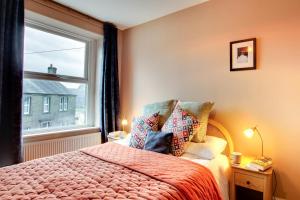 een slaapkamer met een bed en een raam bij Jackdaw Cottage in Embsay