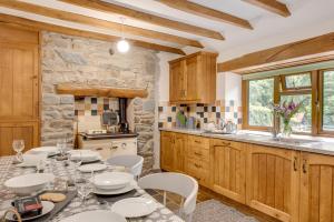Una cocina con una mesa y sillas en una cocina. en Y Felin, en Machynlleth