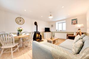 a living room with a couch and a dining room at Flora Belle Cottage in Sennen