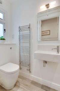 Un baño blanco con inodoro y lavabo. en Ocean View, en Lynmouth 9 fotos más