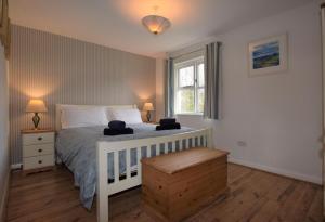 a bedroom with a white bed and a window at Salar Cottage in Georgeham