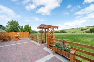 eine Terrasse mit einem Holzzaun und einem Pavillon in der Unterkunft Bryniau Pair Ucha Cottage in Gwytherin