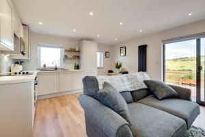 ein Wohnzimmer mit Couch und Küche in der Unterkunft Bryniau Pair Ucha Cottage in Gwytherin