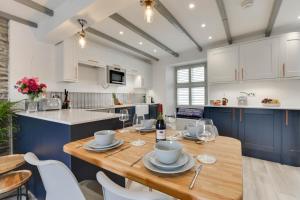 a kitchen and dining room with a wooden table and chairs at Mariners View in Padstow +9 photos