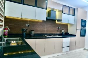a kitchen with white cabinets and a sink at House 8 in Lekki