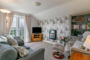 a living room with a couch and a tv at Y Bwthyn in Abererch