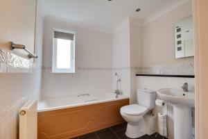 Un baño con bañera, inodoro y lavabo. en Beach Court, en Broadstairs